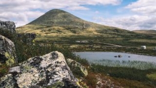 high mountain in valley near calm lake